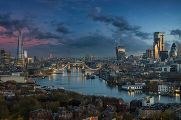 The urban skyline of London along the Thames river with Tower Bridge and Skyscrapers of the City during dawn, United Kingdom