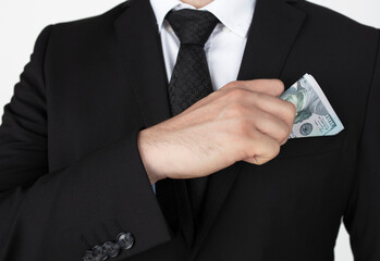 Businessman putting money in suit jacket pocket