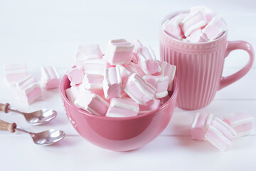 Obraz na płótnie Canvas marshmallow in pink cups close-up. background with pink and white marshmallows in bowls on a white background.