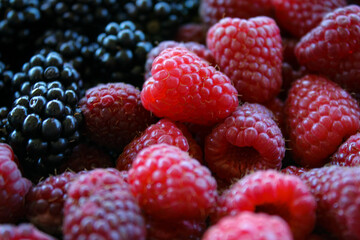 Fresh blackberries and raspberries. Blackberries versus raspberries. Blackberries and raspberries close up, macro. Sweet fresh ripe berries mix. Food background.