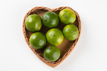 Ripe green lemon fruit in basket with heart shape