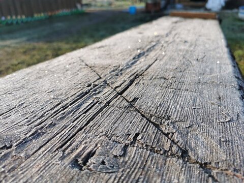 old wooden board in cracks and bitches early spring frost