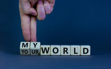 My or your world symbol. Businessman turns wooden cubes and changes words 'your world' to 'my world'. Beautiful grey table, grey background, copy space. Business and my or your world concept.