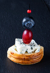 Unusual dietary tapas consisting of baguette, gorgonzola cheese, grapes, and blueberries - a healthy food concept