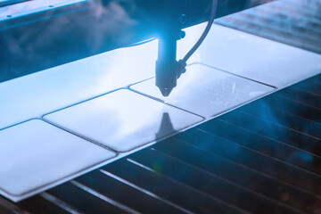 Closeup detail view of a laser cutter during a steel layer shaping process