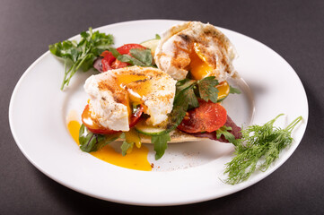 Macro photo of poached eggs. Spreading yolk from eggs. Poached eggs on a white plate.