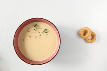 Traditional egg soup in a bowl from Italy's Tuscany region with taralli biscuits - top view
