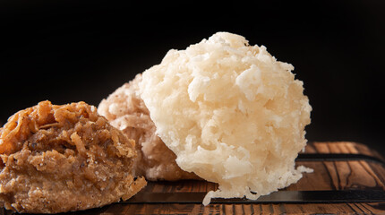 Cocada, Coconut candy from Brazil, white and brown cocadas in close up on a rustic wooden surface and background, selective focus.