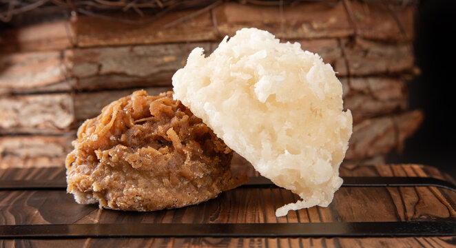 Cocada, Coconut candy from Brazil, white and brown cocadas in close up on a rustic wooden surface and background, selective focus.