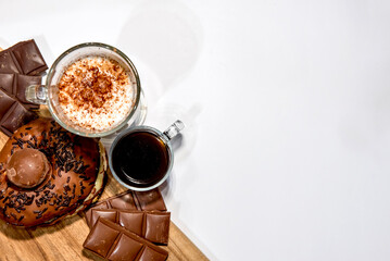 Wooden board with donuts, chocolate, coffee and moccha. Top view.