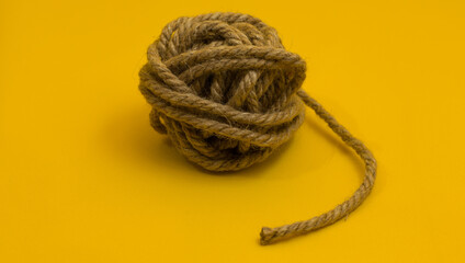 a ball of jute rope on a yellow background