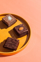 homemade raw energy sweets candies made from natural eco ingredients for healthy lifestyle. dried fruits, nuts, coconut, cocoa bean chocolate. Food fashion trendy minimalistic concept, pink background