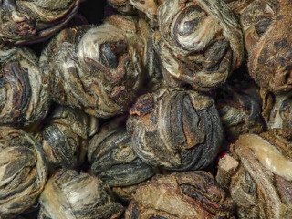 Background Leaves of Chinese green tea twisted in pearls, close-up.