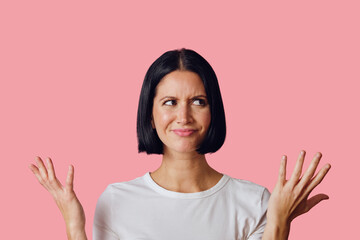 Woman wondering with hands up on the sides thinking looking to the side