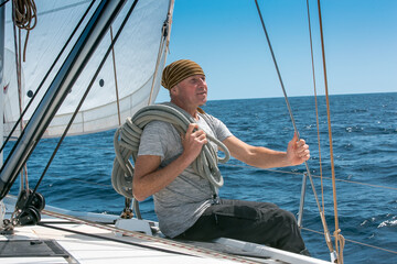 A man on board a sailing yacht at sea. Yachting. Active lifestyle concept.