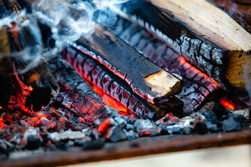 Close-up firewood, hot coals and ash. Lighting barbecue coals.