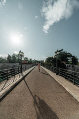 Kobieta spacerująca po moście w słoneczny dzień