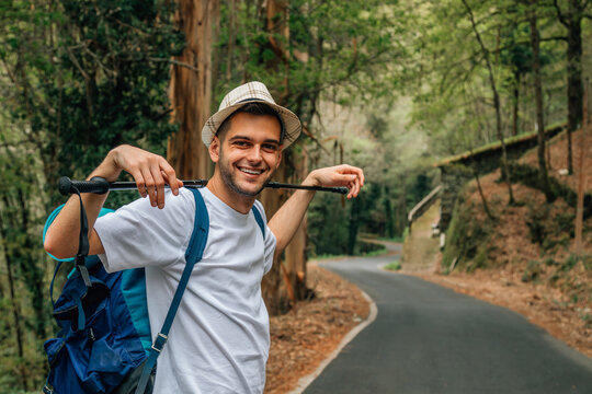 happy young man hiking with backpack outdoors