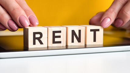 woman made word RENT with wooden blocks, business concept