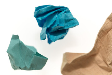 crumpled cerulean blue, teal green, and sand brown patterned and textured paper on white