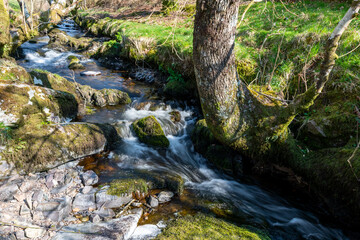 Long exposure of the Weir Water river  flowing through the valley at Robbers Bridge in Exmoor...