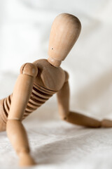 isolated wooden mannequin, mannikin, manikin - close up, lying down, belly down