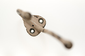 antique or traditional style painted metal coat hook, isolated on white, viewed from the top, with focus on screw holes