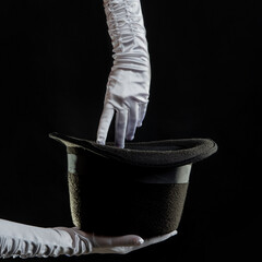 Hand gestures. illusionist holds a hat in his hands and shows magic and tricks.