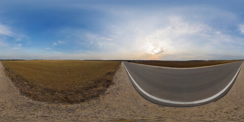 Country asphalt road among fields at sunset or sunrise with beautiful sky and cirrus clouds,...