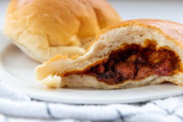 Baked char sui bao or BBQ pork buns showing the filling inside