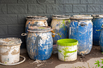 Industrial Waste, Plastic barrels of paint. High Angle View Of Liquids In Containers Against Wall. Dirty containers with stains of dye. Barrel covered with multicolored spots