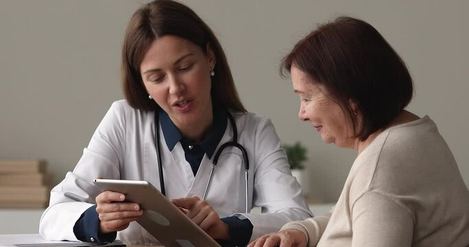 Doctor explain to older patient medical test result on tablet, use website gives recommendation about disease treatment medications show positive forecast. Medicine and modern tech usage app concept
