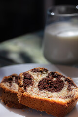 Close up view of Marble cake slice on white plate and wooden table. High quality photo