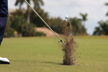 The moment of impact with an iron. Scattered grass 