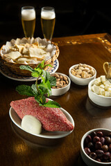 Traditional Middle Eastern food. Lebanese food. Arabian raw kibbeh, olives, cheese, beer glass