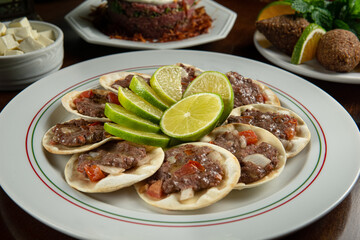 Traditional Middle Eastern food. Lebanese Sfiha meat. Arabian sfeeha plate. Esfiha with lemons. Kibbeh Kibe