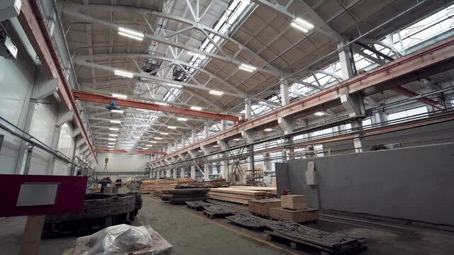 Inside huge industrial factory workshop interior with stacks of wood for making molds.