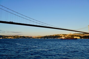 Tourist boats sail under the bridge in Istanbul. Traveling on the Bosphorus. Panoramic view, View of the First Bosphorus Bridge sailling Bosporus.