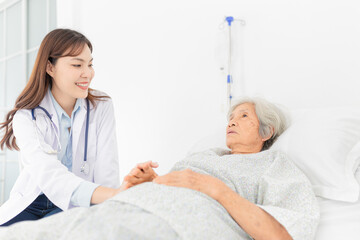 Fototapeta premium close up patient, doctor screening old asian patient, elderly health check up , they talk about symptoms together, doctor holding hand of patient, palliative care