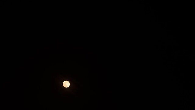 Glowing Moon rising in The Black Sky Above