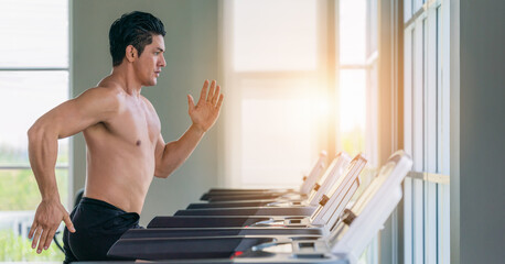athletic man doing running exercise on treadmill in gym and fitness center