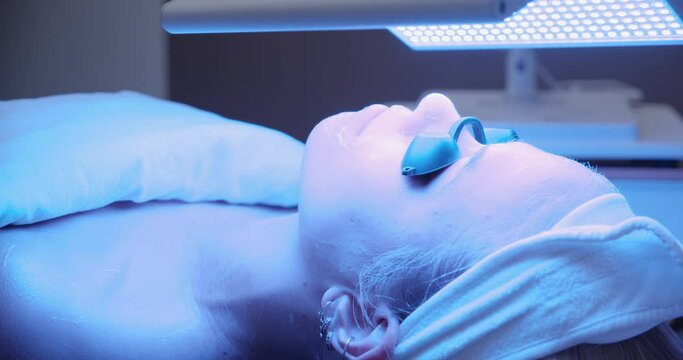 Young Woman In Blue Then Red Sunbed Light