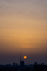 Obraz premium 神戸市東灘区の高層マンションからの日の出、東の空がオレンジ色に染まり、神戸・芦屋・西宮の街並みがシルエットで浮かぶ。一日の始まり