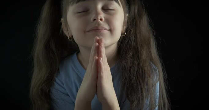 Portrait of a praying little girl.