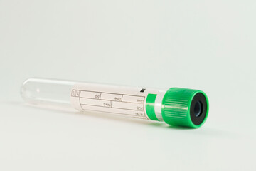 vacuum tube for collection and blood samples on white background..Transparent with green lid. Label...