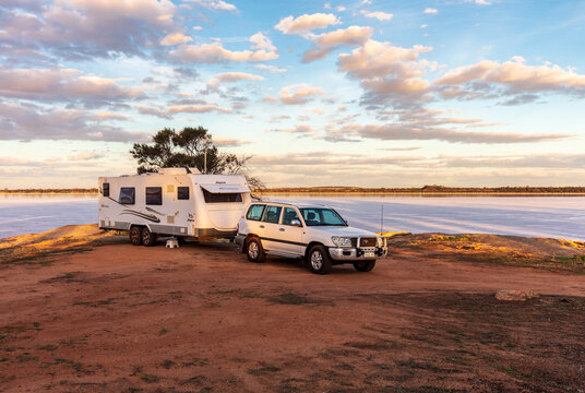 Wagin, Australia - Mar 12,2021: A large white caravan and modern 4WD vehicle free camp next to the nearly dry salt Lake Norring which was once a popular water skiing area