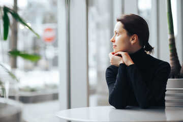 Pretty woman waiting on a table near window. Free space for your text