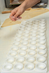 hands arranging fresh homemade sorrentino pastas in boxes for delivery on counter with flour and work items