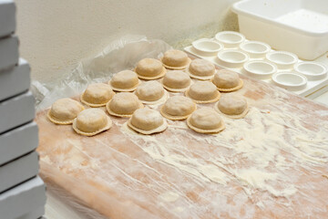 hands arranging fresh homemade sorrentino pastas in boxes for delivery on counter with flour and work items