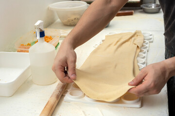 hands arranging fresh homemade sorrentino pastas in boxes for delivery on counter with flour and work items